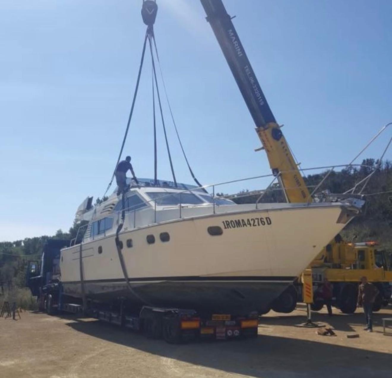Yacht sollevato con una gru sopra un semirimorchio