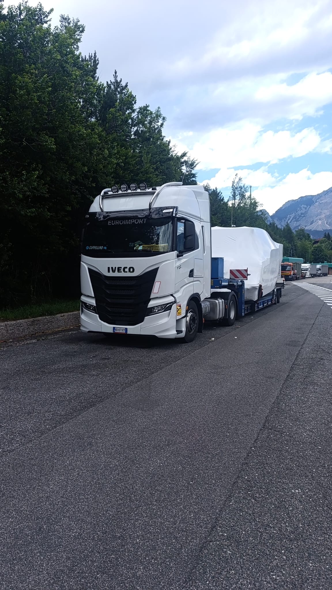Camion con imbarcazione coperta su una strada di montagna