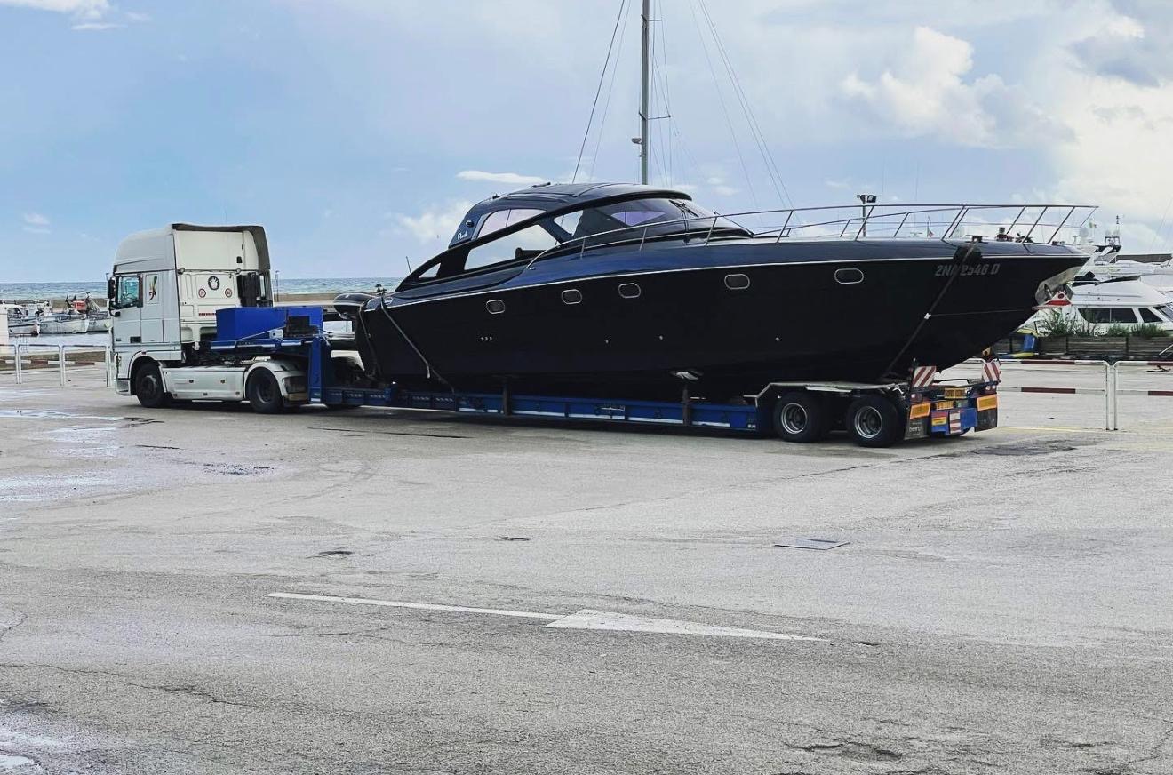 Yacht nero su rimorchio ribassato vicino al porto